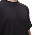 Tricou oversize negru, prim-plan al materialului moale și cusăturilor de calitate.