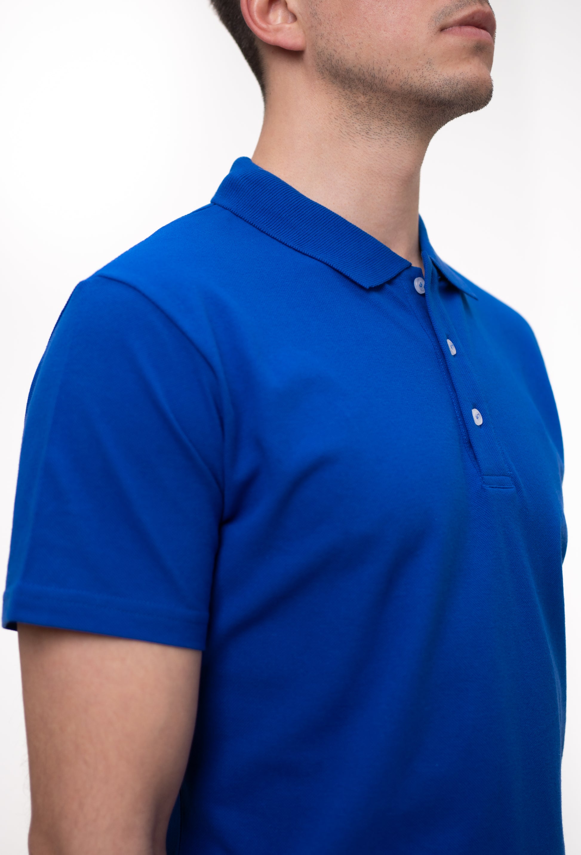 Tricou polo albastru electric din bumbac, vedere laterală și detalii de croială.